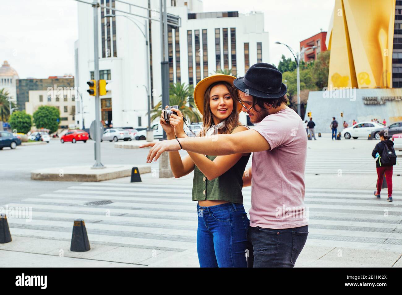 Portrait of a young couple traveling and taking a photo on street of Mexico City center Stock Photo