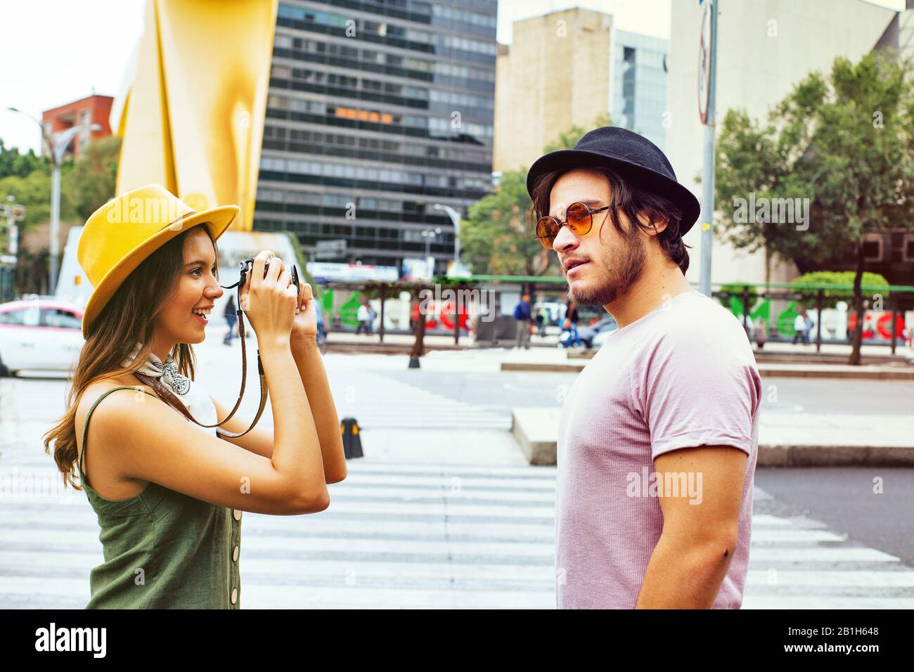 Portrait of a young couple traveling and taking a photo on street of Mexico City center Stock Photo