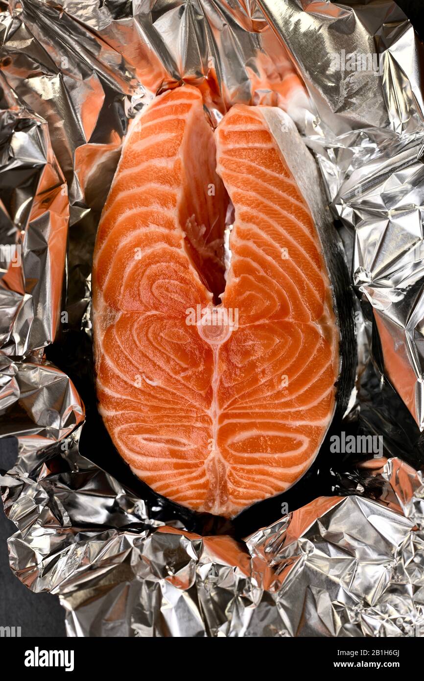 Horizontally placed salmon steak on aluminum foil with ice. Stock Photo