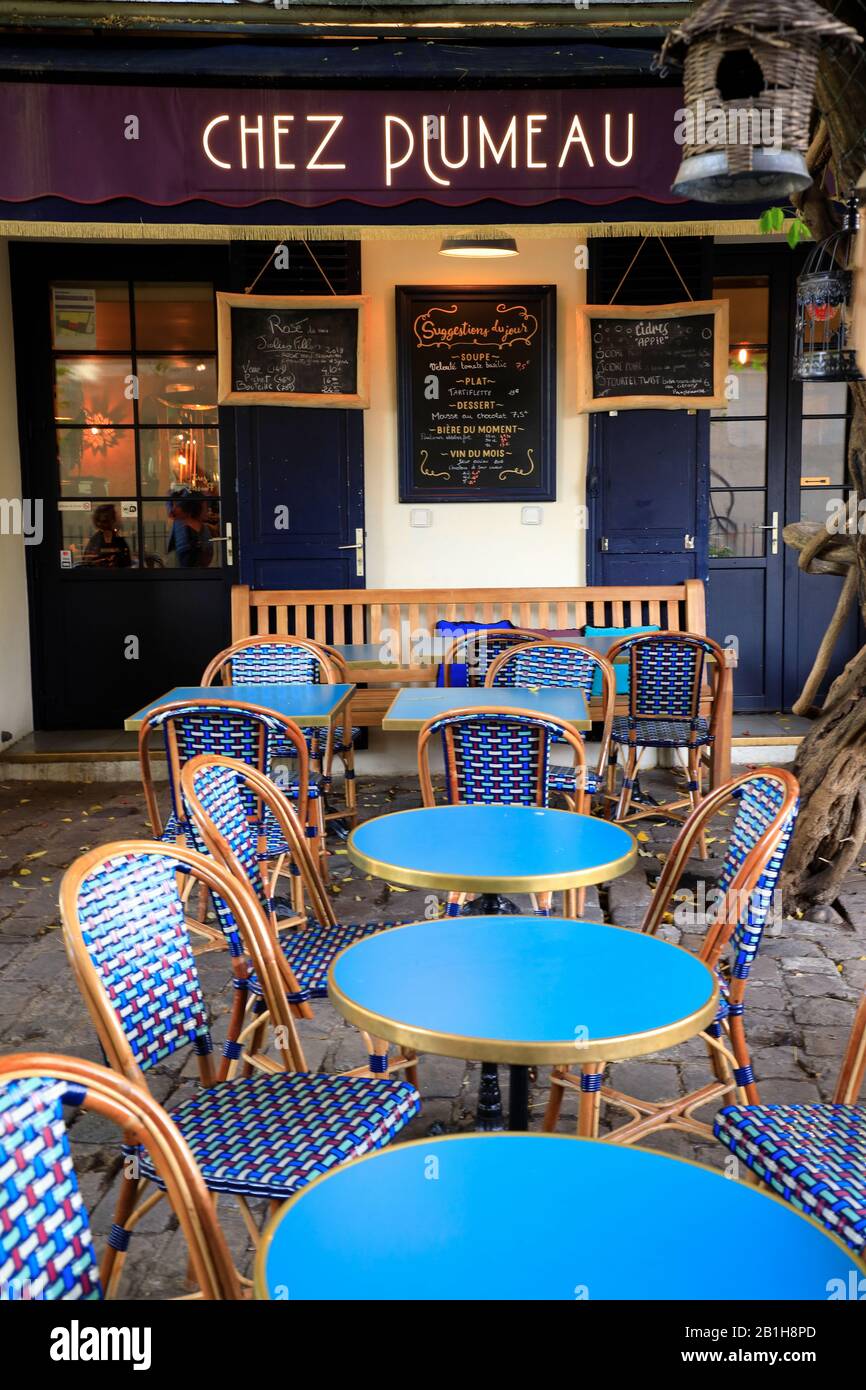 Blue chairs and tables in typical Parisian cafe style in the outdoor seating of Chez Plumeau restaurant.Montmartre.Paris.France Stock Photo