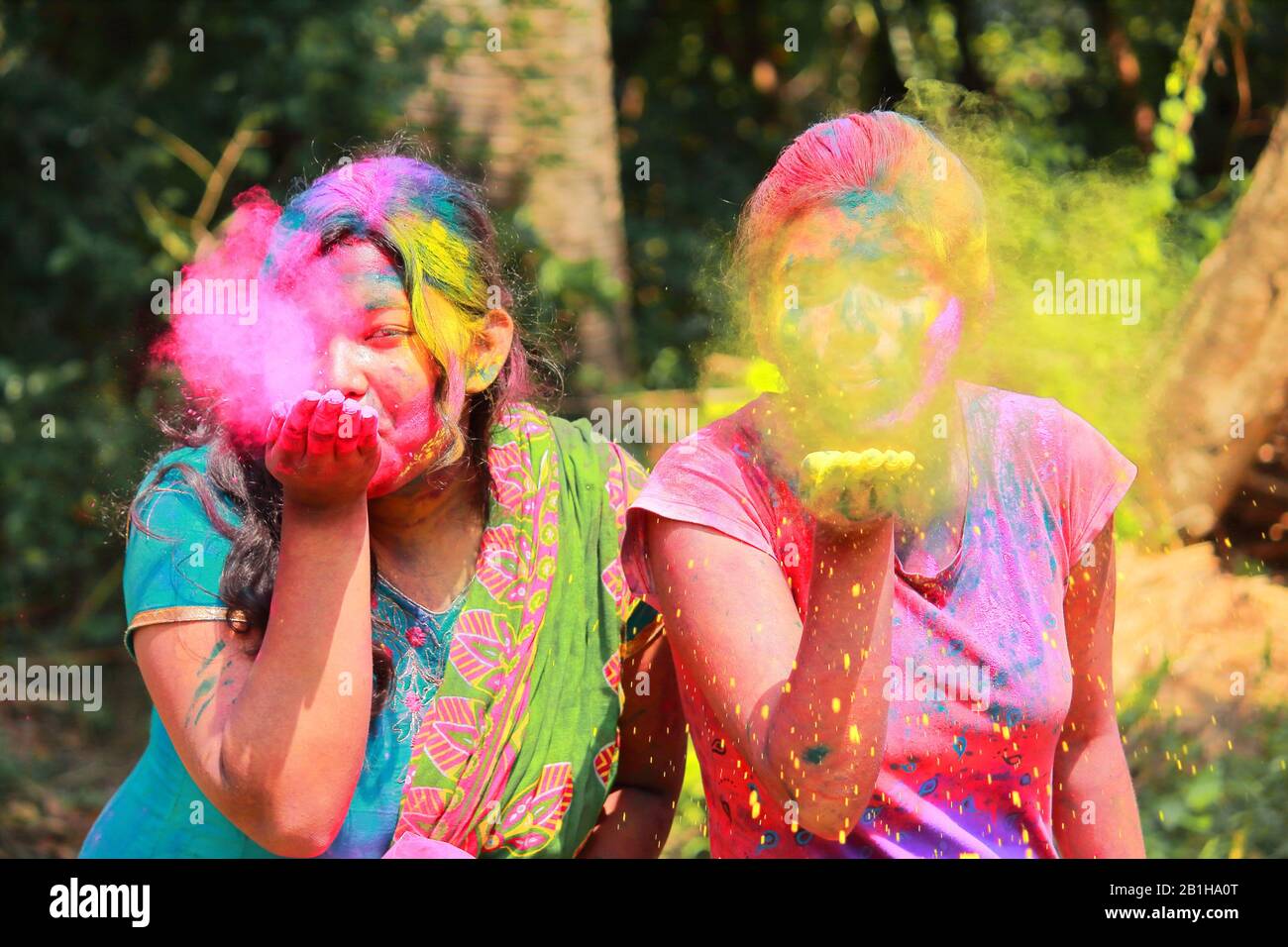 two young joyful girls celebrate holi festival with colorful abir in kolkata, west bengal, india Stock Photo
