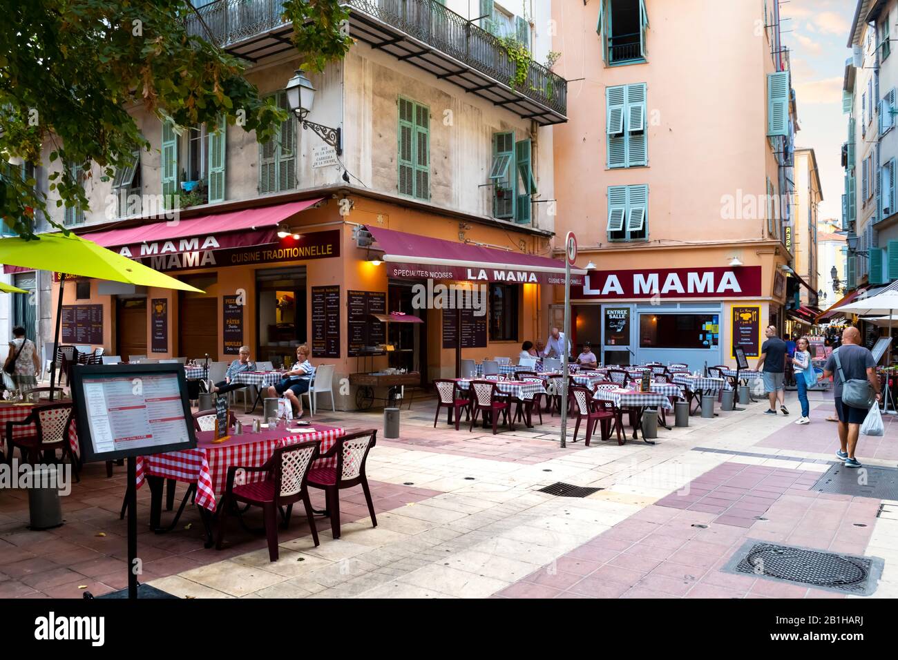 A sidewalk Italian cafe with tables on the patio in the Old Town Vieux section of Nice, France, on the French Riviera. Stock Photo