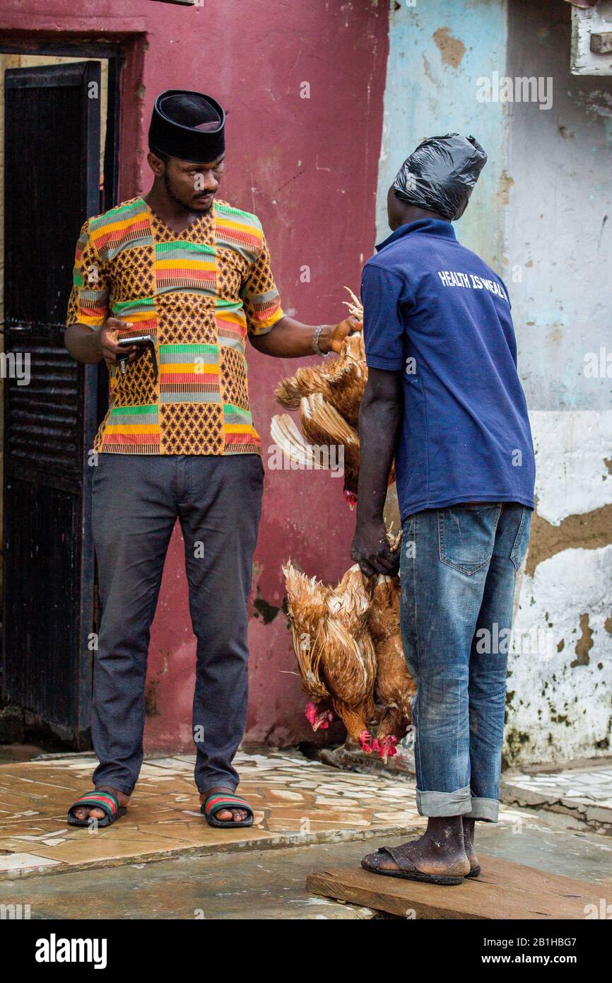 A man buying a live chicken being hawked on the streets of Abuja during Christmas celebrations in Nigeria. Stock Photo