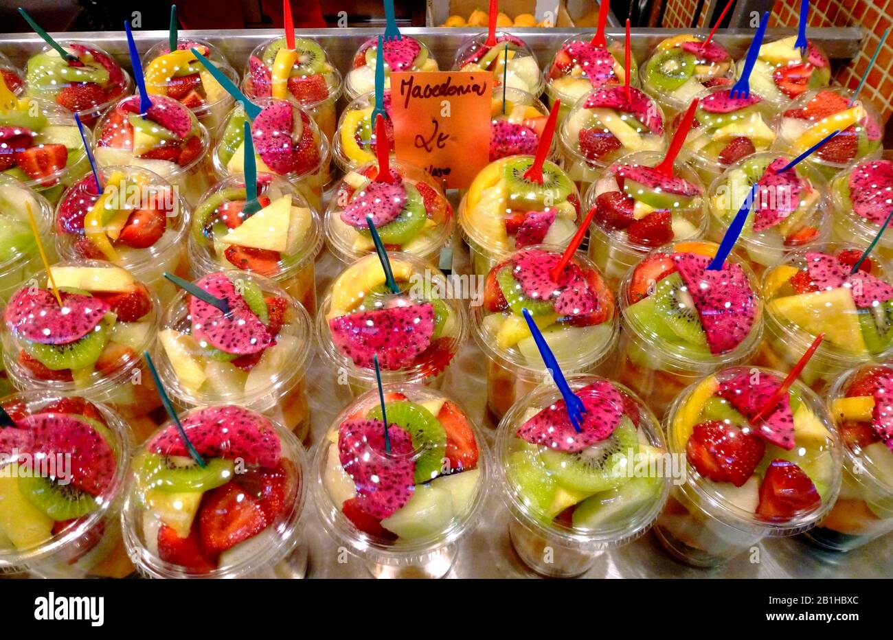 fruit cups. freshly sliced fruit mixture in plastic cups with lid and colorful forks in a fruit