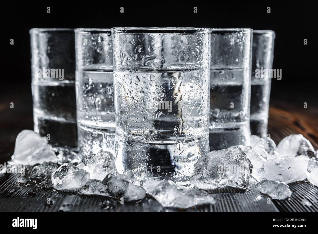 Vodka in shot glasses on rustic wood background. creative photo Stock
