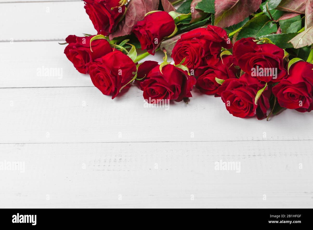 Romantic background with red rose on wood table Stock Photo - Alamy