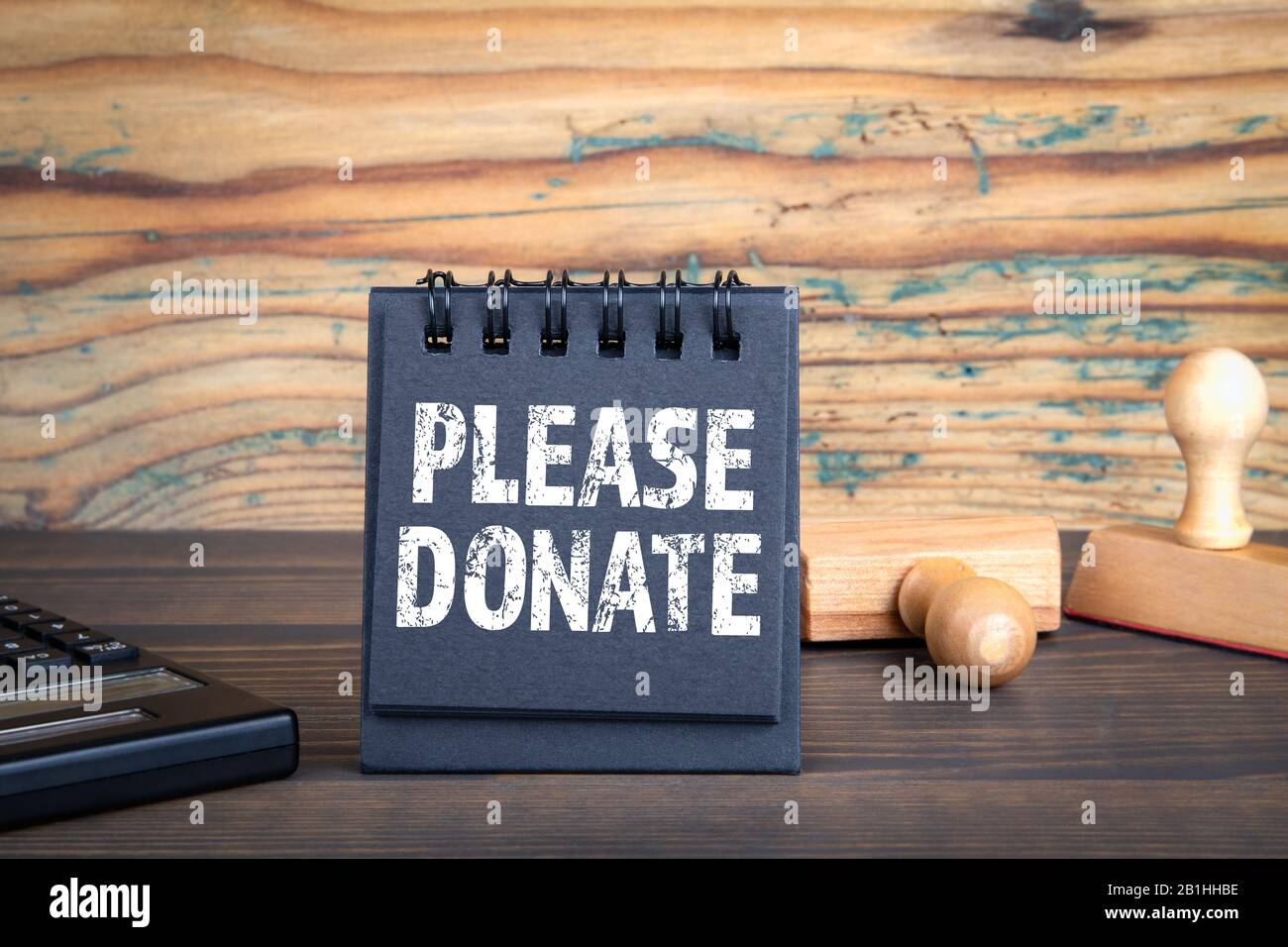 PLEASE DONATE. Charity, help, compassion, empathy and rescue concept.  Notebook, stamps and calculator on a wooden background Stock Photo - Alamy