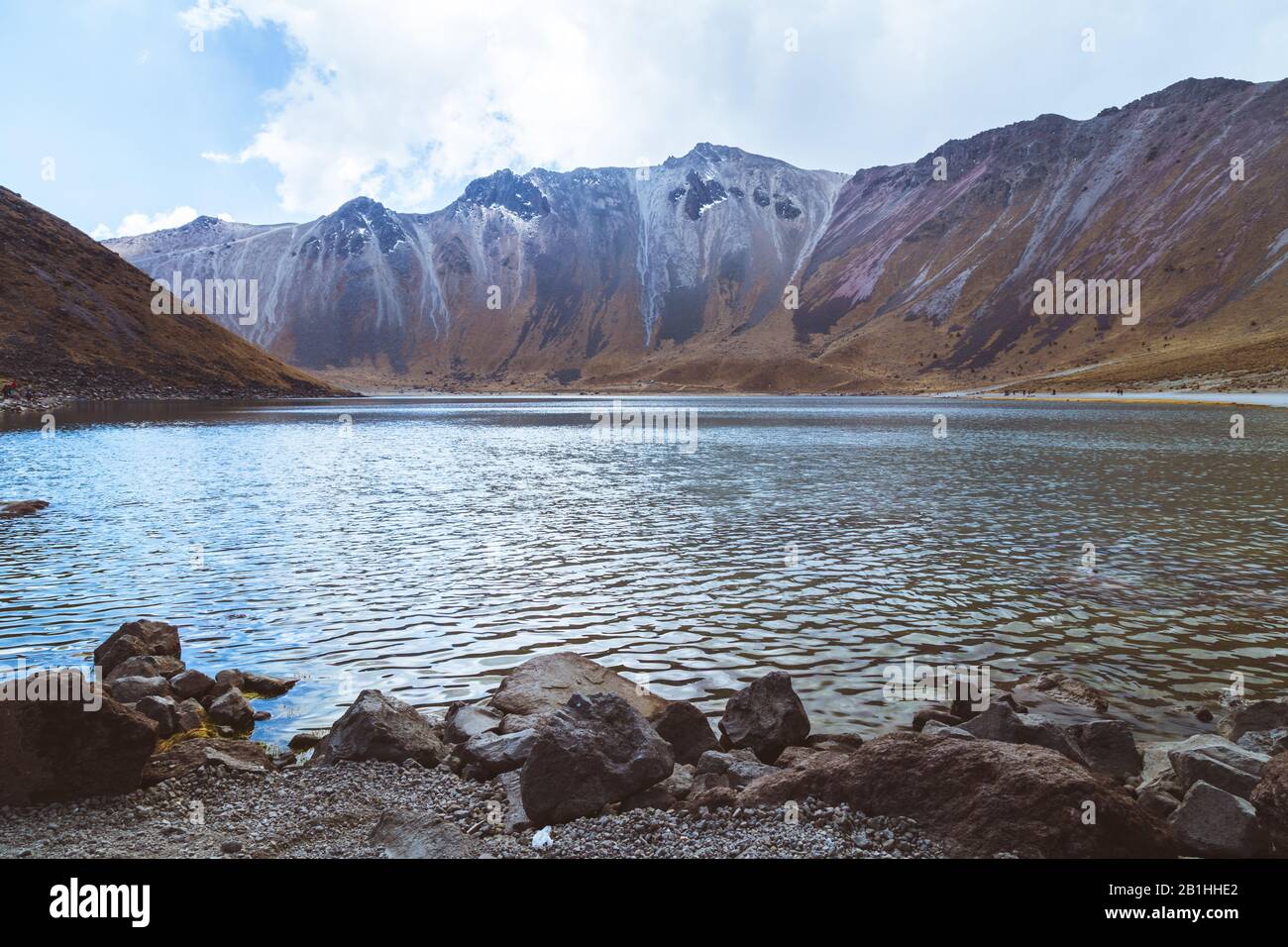 A lake with crystal clear waters, surrounded by snowy mountains and a ...