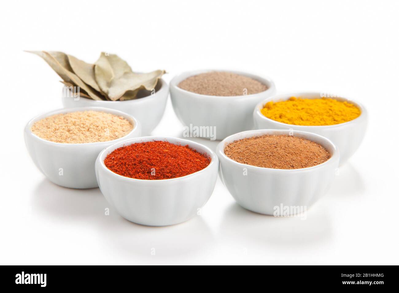Different spices in white bowls isolated on white background. Paprika