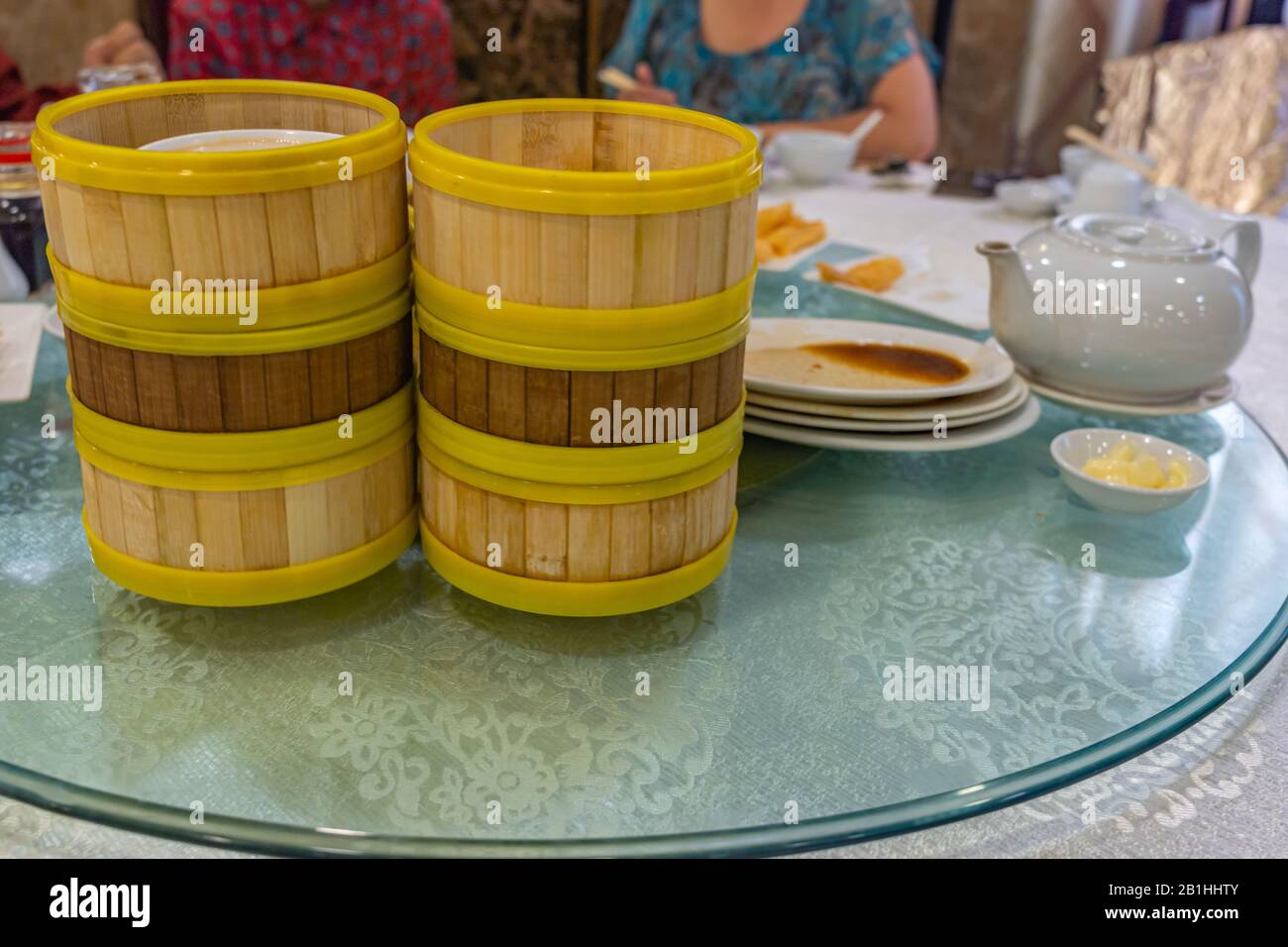 Stack of empty dimsum bamboo steamer boxes on dining table Stock Photo