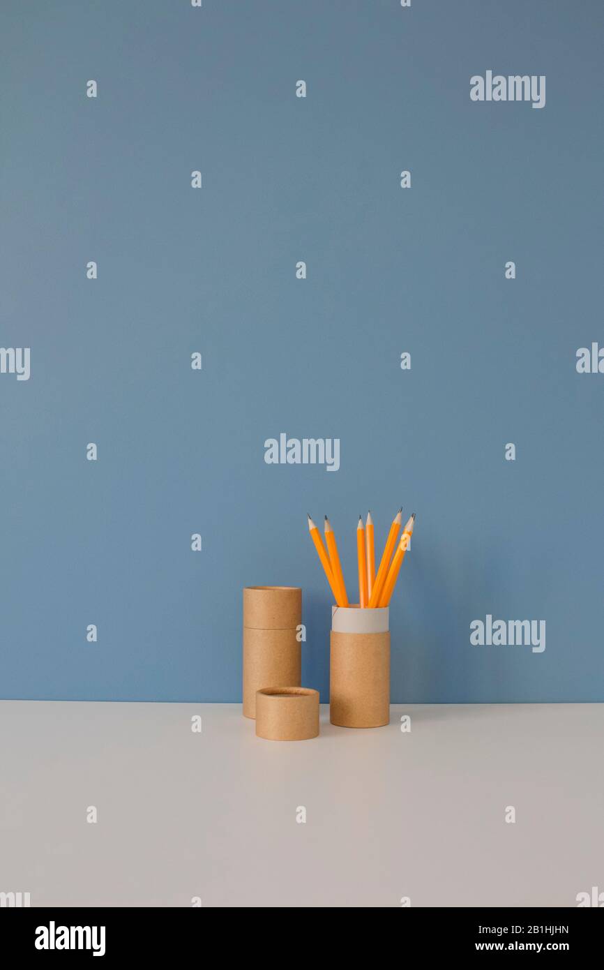 Paper Tubes With Yellow Pencils On White Table On Blue Background paper-tubes-with-yellow-pencils-on-white-table-on-blue-background