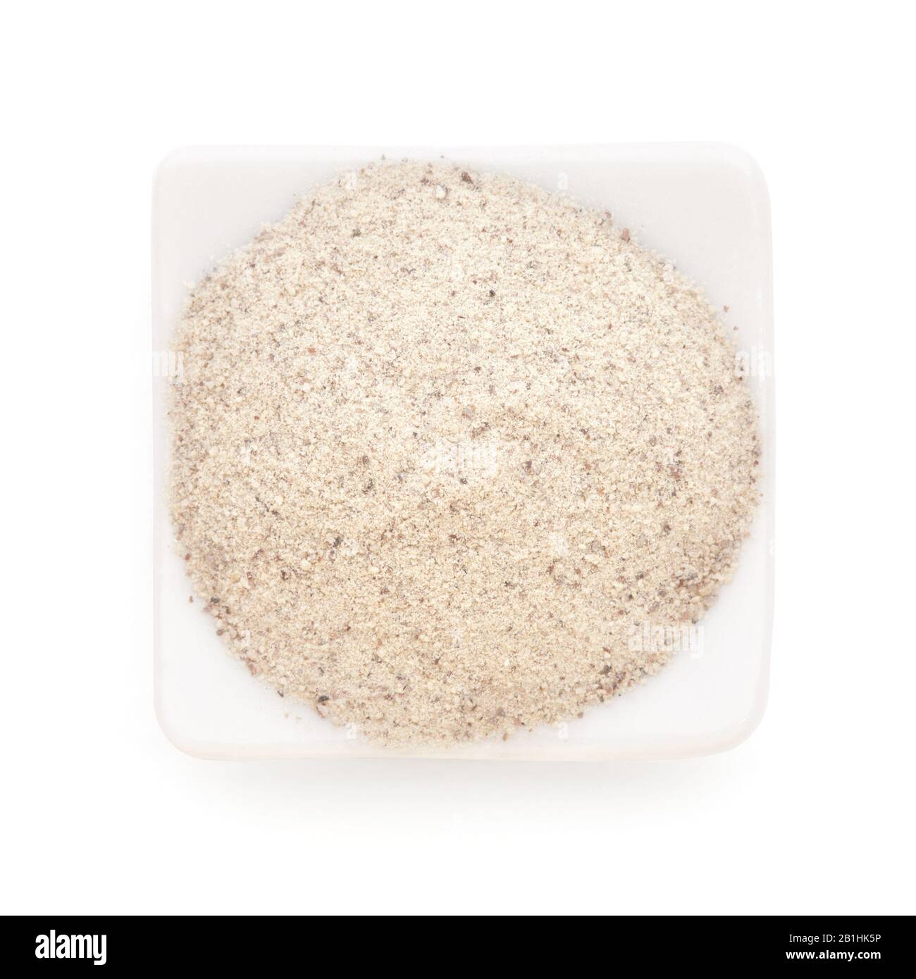 White Pepper ground in a white bowl on white background. Used as a spice in cuisines all over the world. Stock Photo