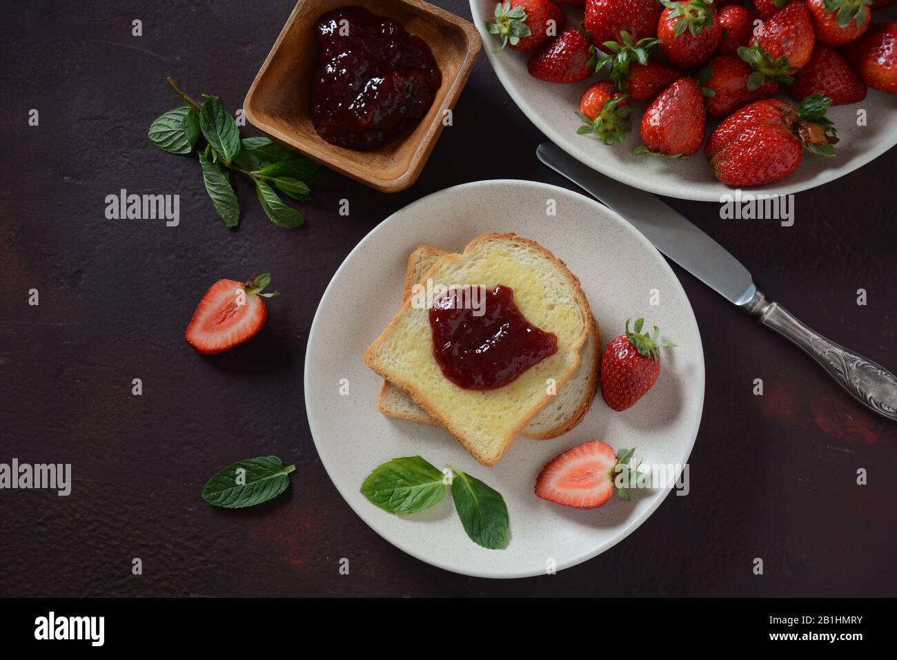 Toasts with strawberry jam for breakfast, rustic style Stock Photo