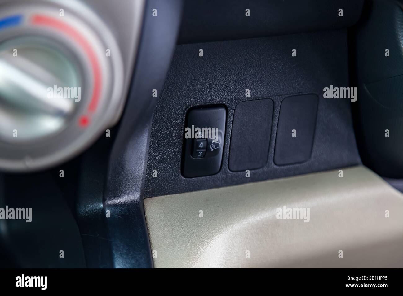 Black button for turning electric headlight range adjustment of the car