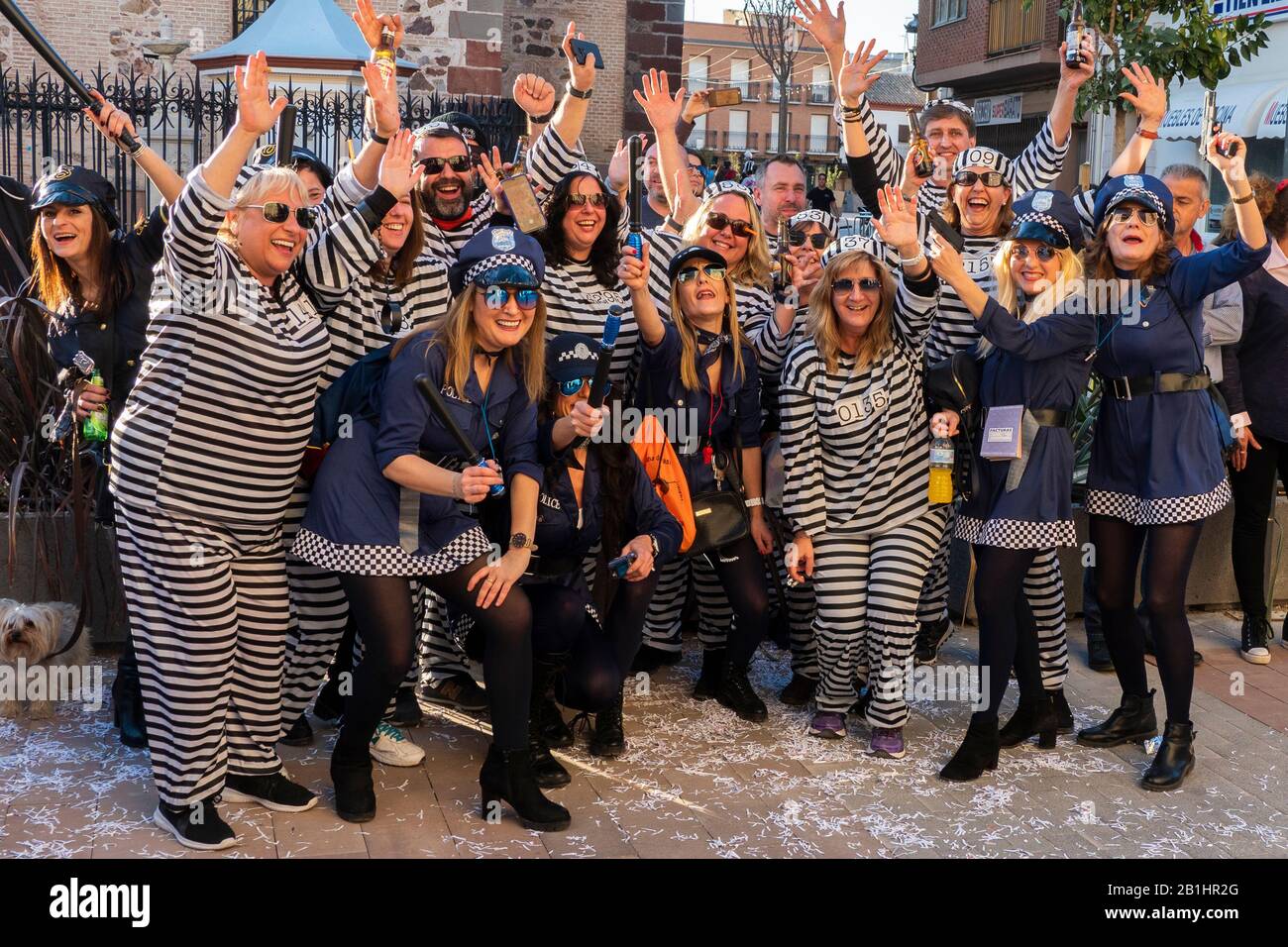 group of people dressed as police and prisoners at Street carnival parade  Herencia, Castile-La Mancha, Spain February, 22, 2020 Stock Photo