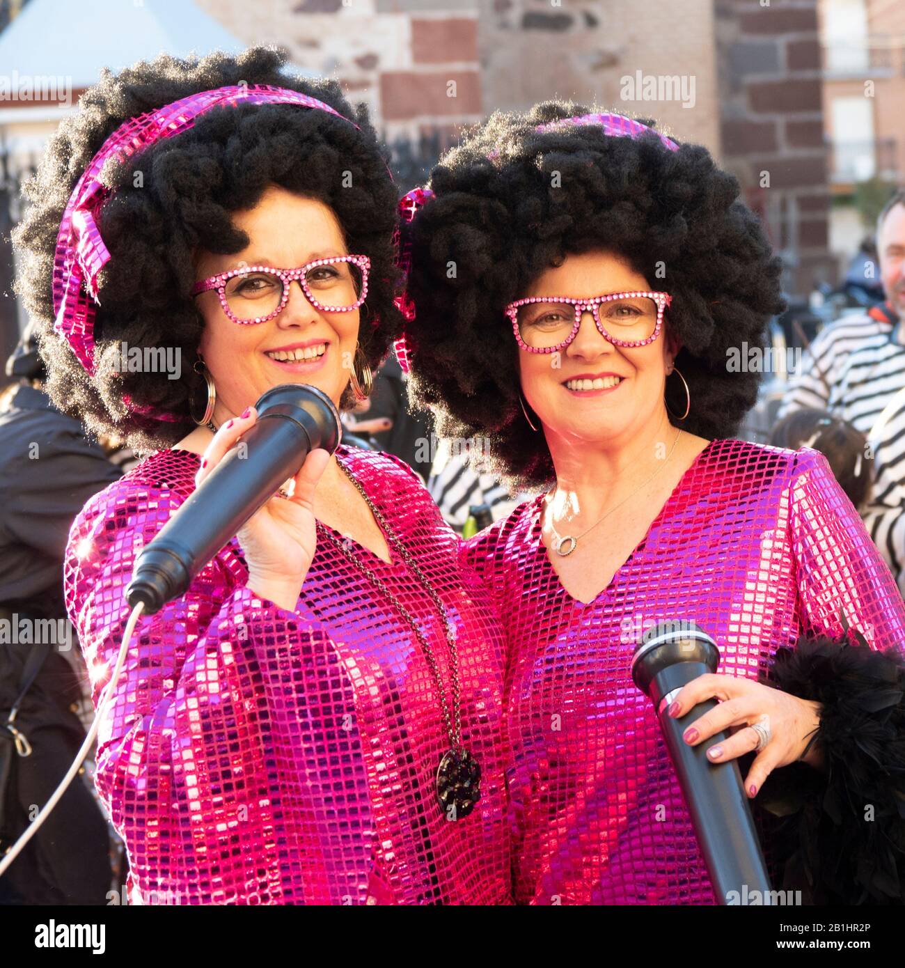 two women dressed as singers, with wig and brightly colored dress  Herencia, Castile-La Mancha, Spain February, 22, 2020 Stock Photo