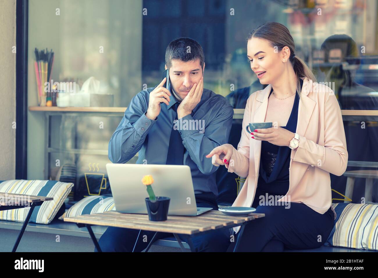 Successful business partners remote working at cafe terrace Stock Photo