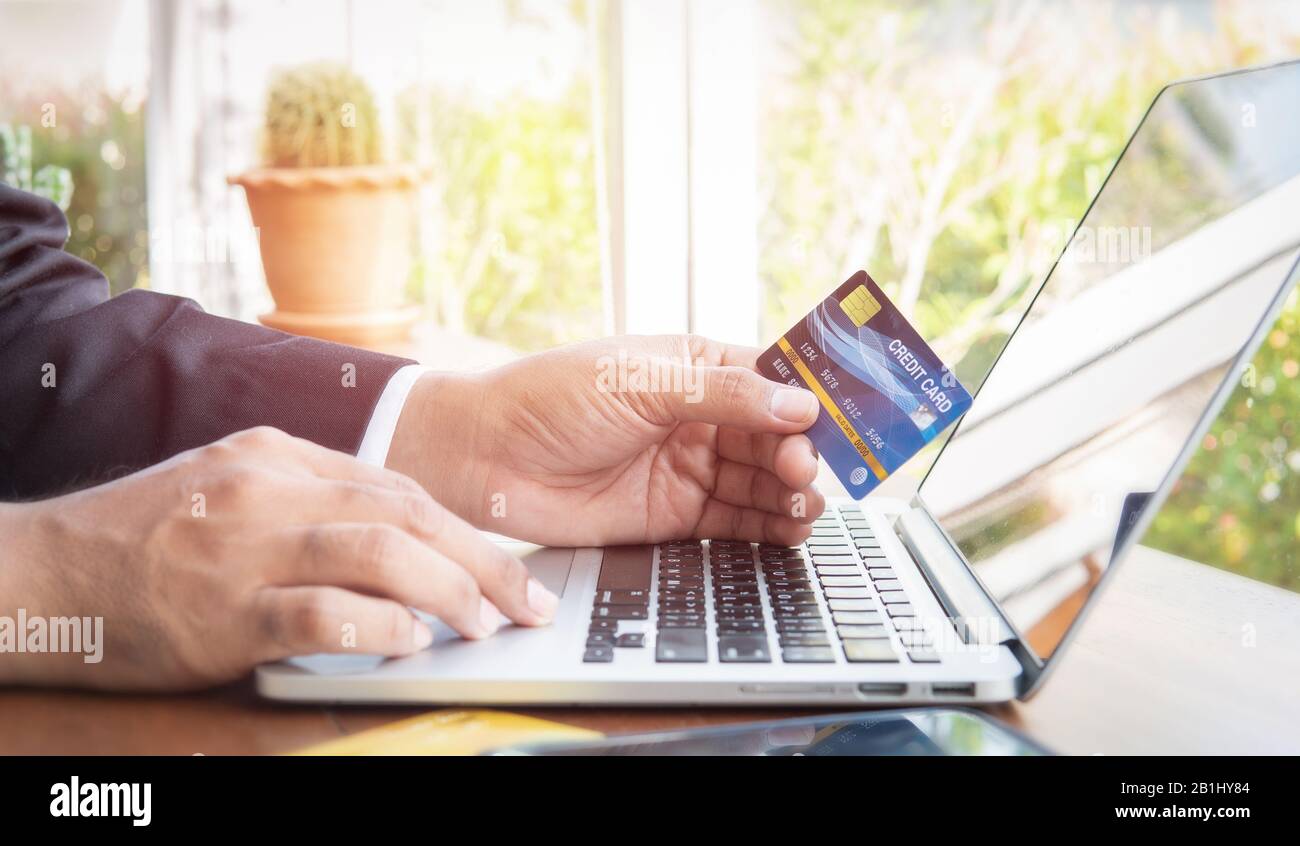 Business man hand hold credit card to shopping internet online bill on ...