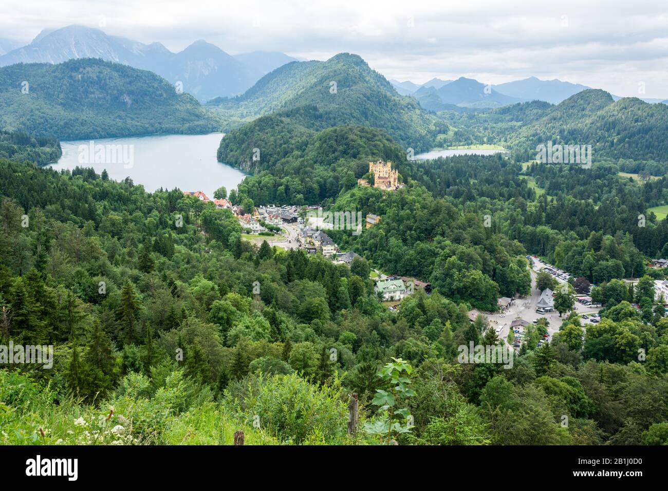 View from Neuschwanstein castle in Germany showing (left to right): palace access road; Alpsee with locality of Hohenschwangau in front; nineteenth ce Stock Photo