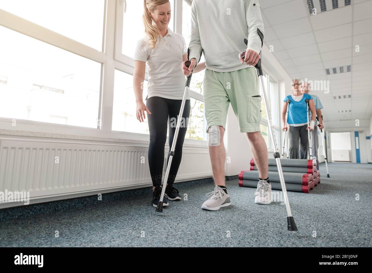 People in rehabilitation learning how to walk with crutches Stock Photo -  Alamy