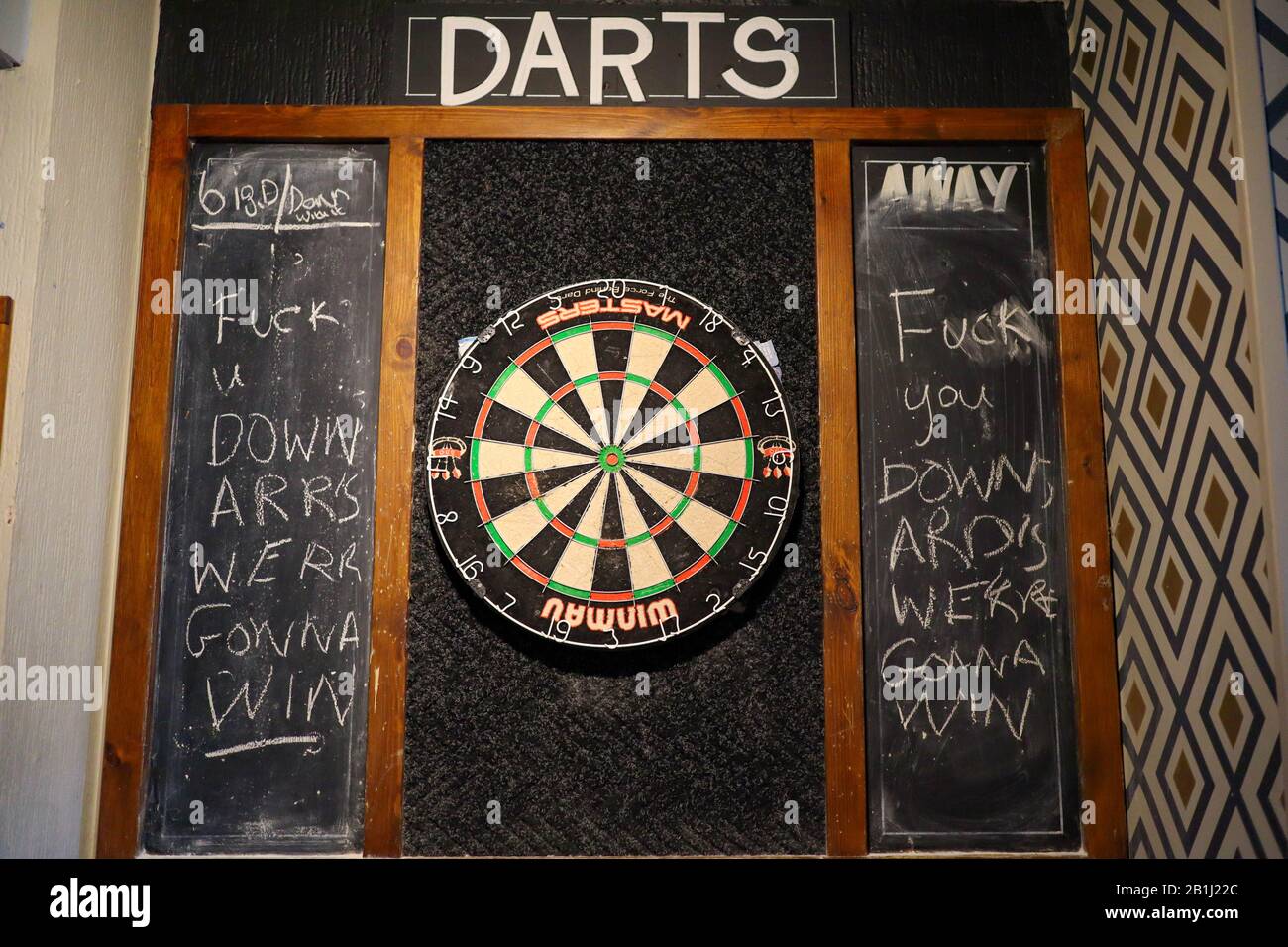 Ashbourne, UK. 25th Feb, 2020. A dart board in Ye Olde Vaults pub with message for the Down’Ard’s. The first day of the two day Shrovetide Football Game in the market town of Ashbourne, Derbyshire. The game is played with two teams, the Up'Ards and the Down'Ards. There are two goal posts 3 miles (4.8 km) apart, one at Sturston Mill (where the Up'Ards attempt to score), other at Clifton Mill (where the Down'Ards score). Penelope Barritt/Alamy Live News Stock Photo
