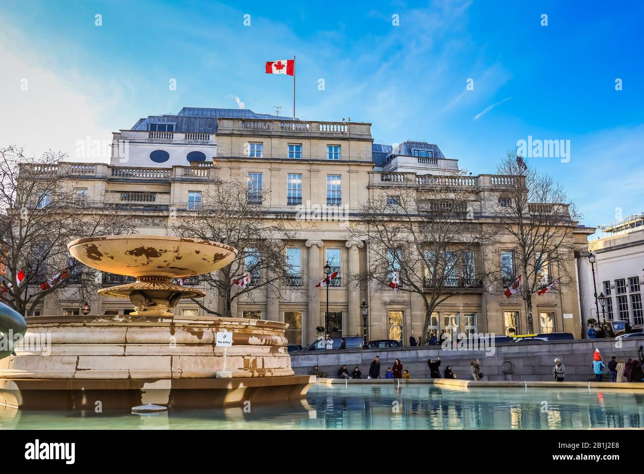 Canadian embassy in London. Located in Trafalgar Square.  Famous fountain and unrecognizable people in the foreground. Stock Photo