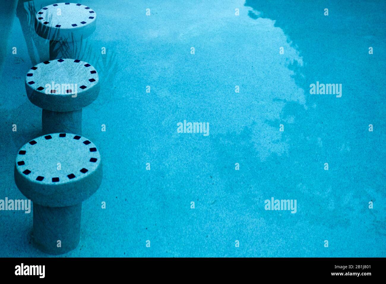 Pool stools submerged under water in swimming pool. Architectural