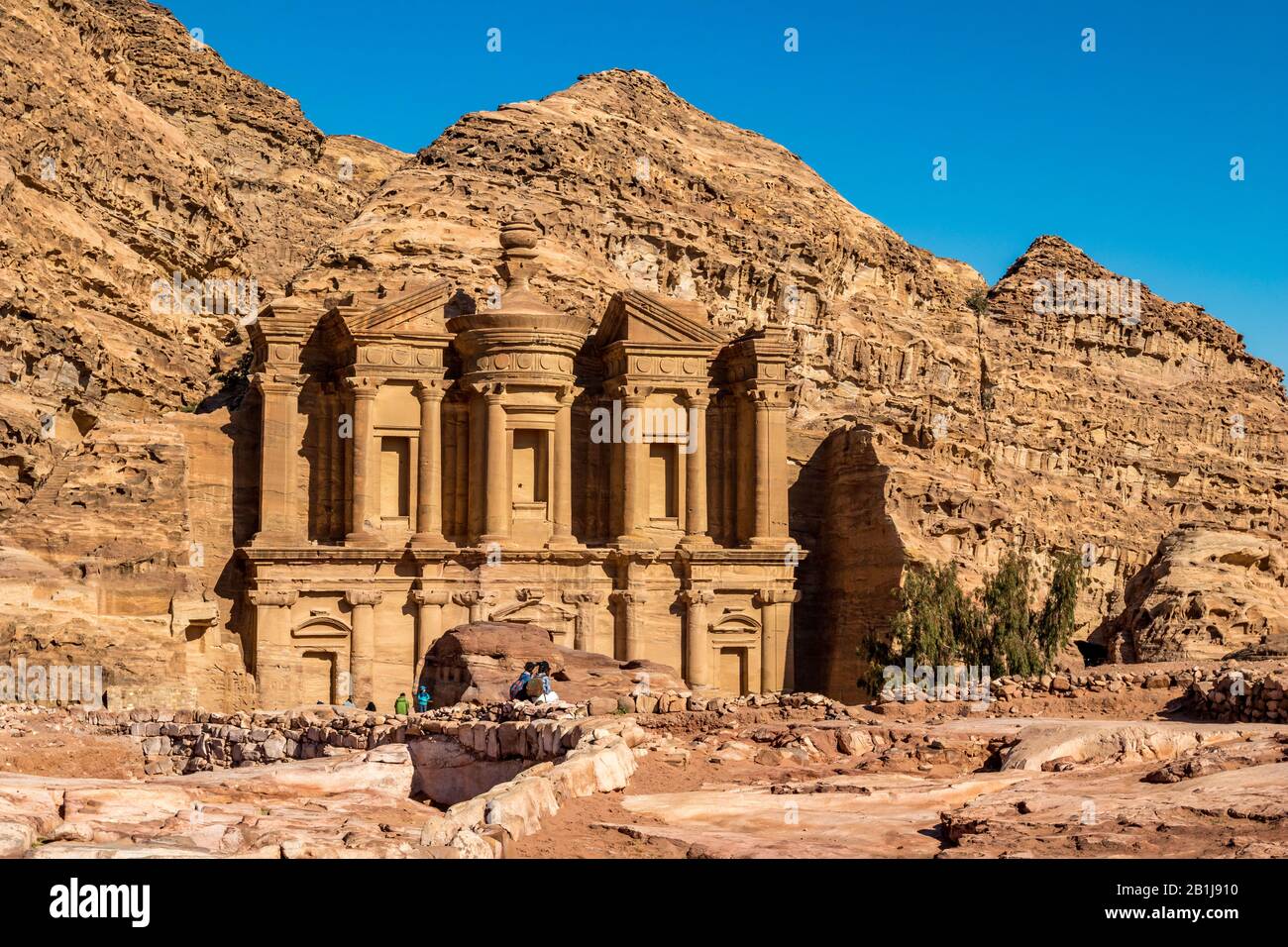 PETRA, JORDAN - JANUARY 30, 2020: The stunning Ad-Deir in ancient city of  Petra, Jordan. Ad-Deir or The Monastery, Hashemite Kingdom of Jordan is lit  by the warm winter sun, cloudless sky