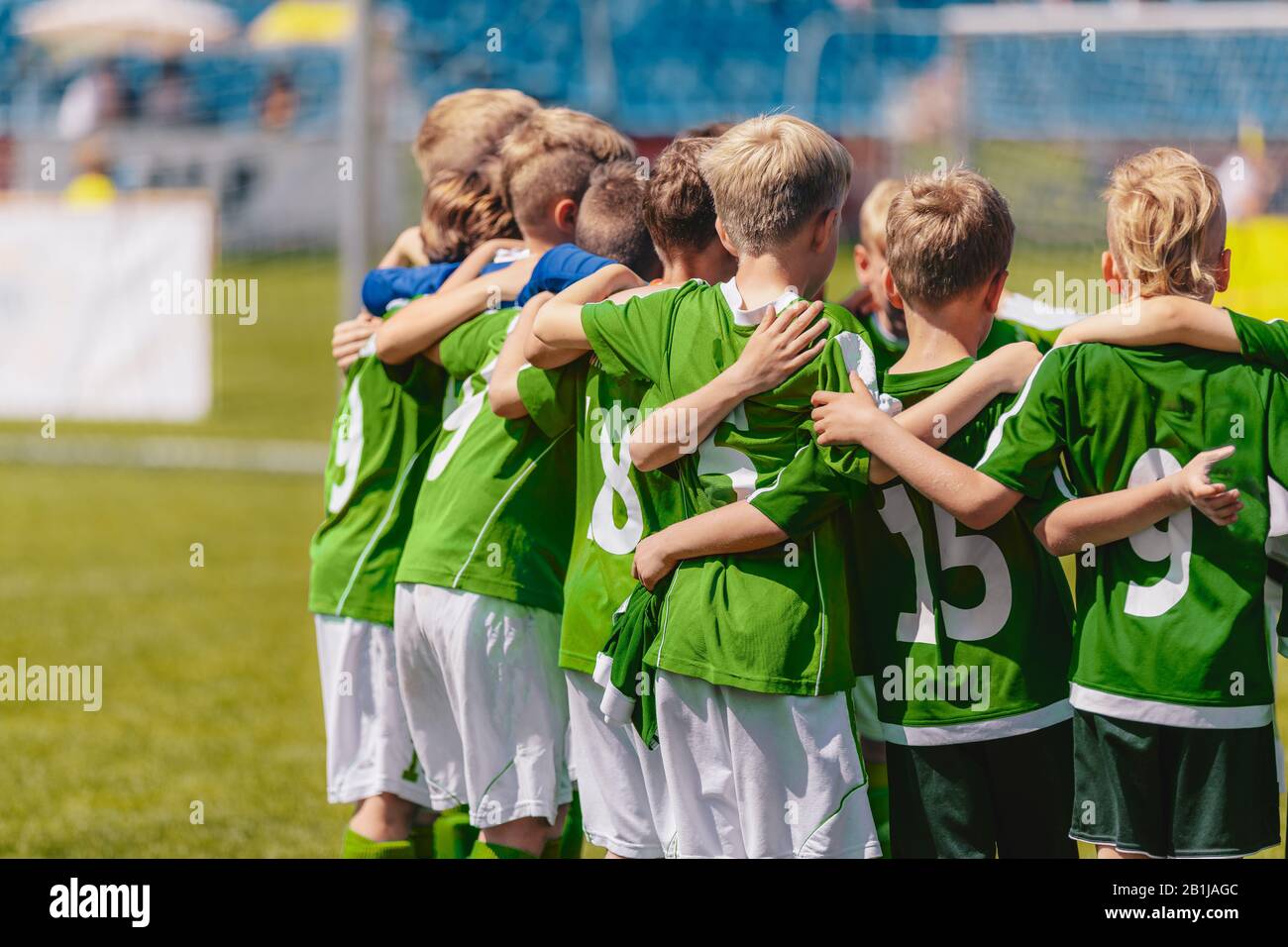 Kids elementary school sports team in green jersey shirts. Child soccer  team huddling. Junior sports team huddle at the stadium Stock Photo - Alamy