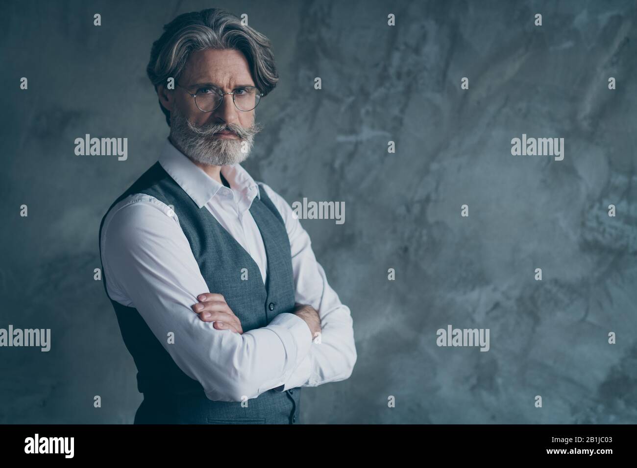 Turned photo of elegant gorgeous old millionaire man cross hands look good copy space wear modern clothes isolated over concrete wall grey color Stock Photo