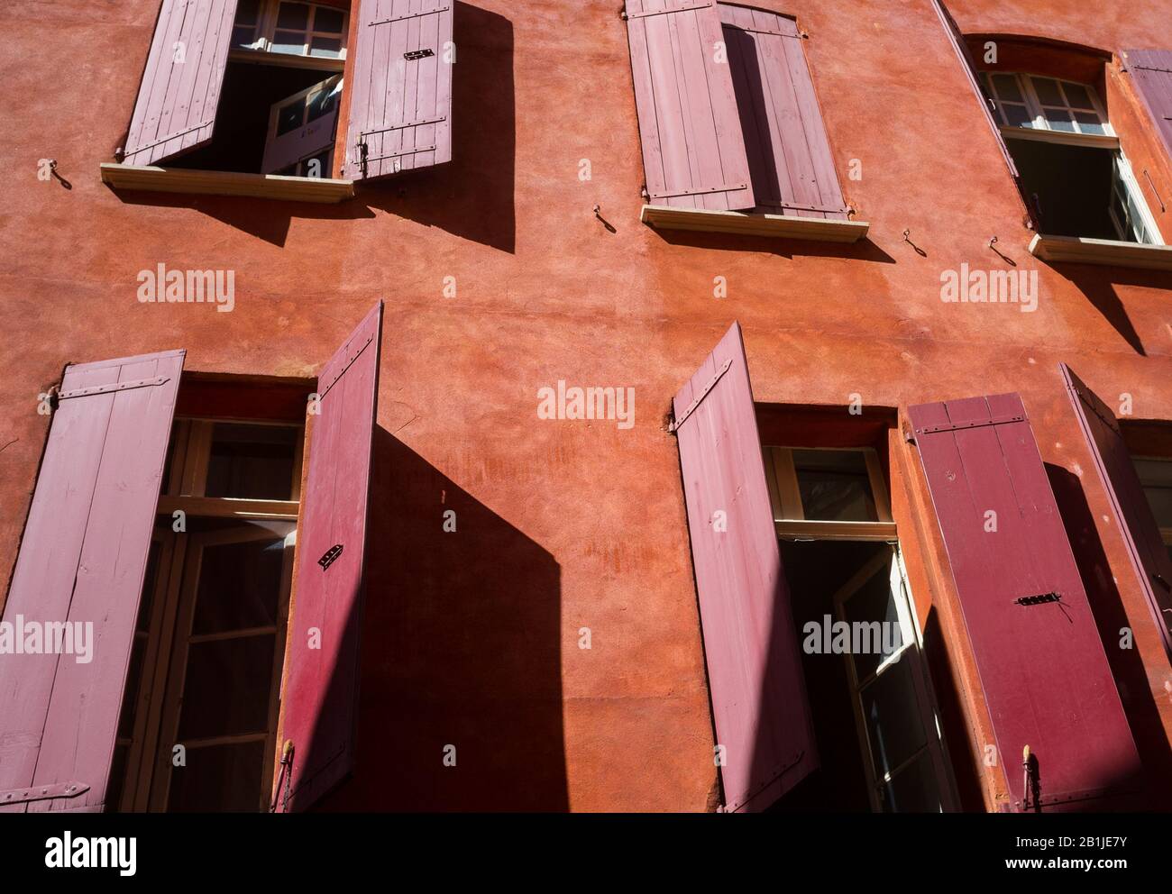 Red shutters on the windows of a house with red walls in the Old City