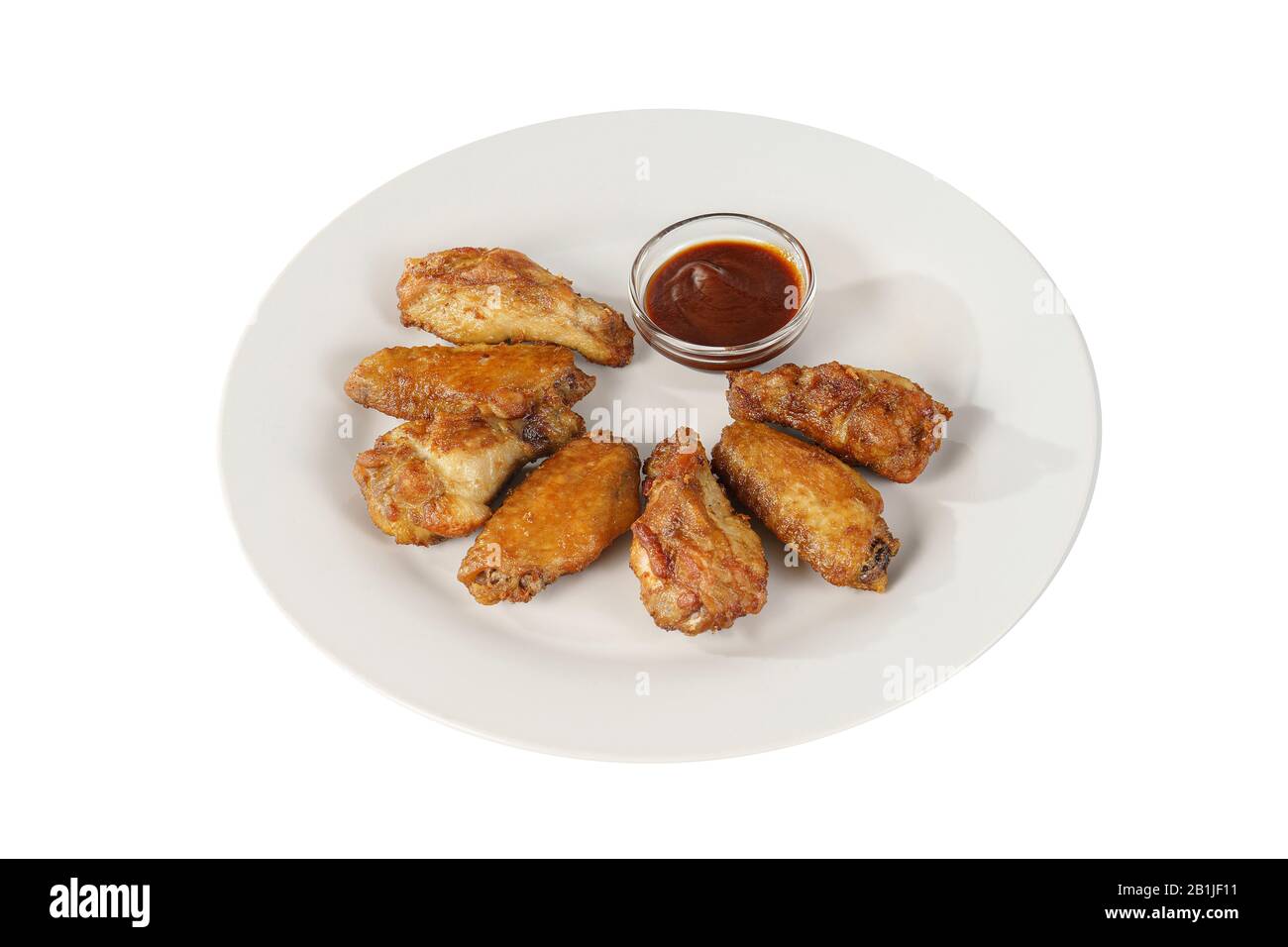 Hot appetizer chicken pieces, legs, wings, fried in oil, tomato sauce, ketchup, B-B-Q, before alcohol, on plate, white isolated background, Side view. Stock Photo
