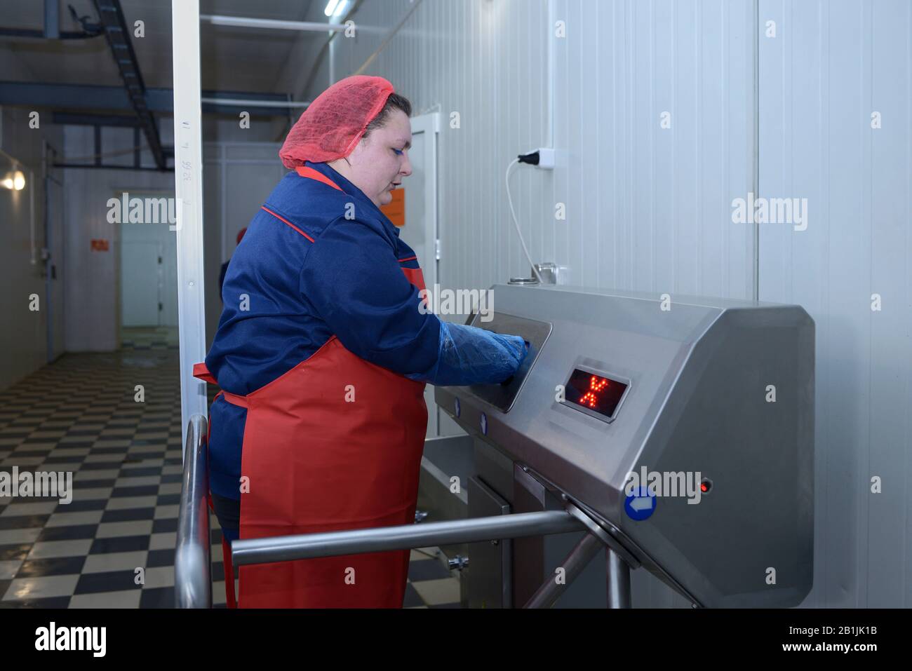 At the sanitary inspection room. Female worker disinfecting hands before entering the slaughter hall. April 22, 2019. Kiev, Ukraine Stock Photo