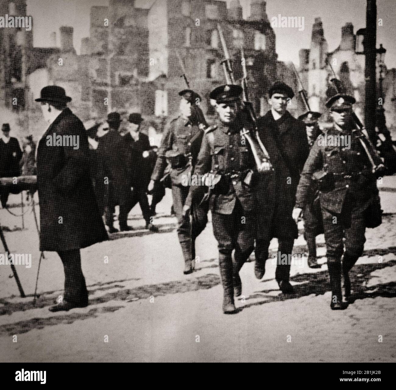 An Irish nationalist is led under escort by British oldiers to Dublin Castle following the Easter Rising of 1916, an armed insurrection in Ireland during Easter Week, April 1916. It was launched by Irish republicans to end British rule in Ireland and establish an independent Irish Republic while the United Kingdom was fighting the First World War. It was the first armed action of the Irish revolutionary period. Sixteen of the Rising's leaders were executed in May 1916, but subsequent  political developments ultimately contributed to Irish independence. Stock Photo