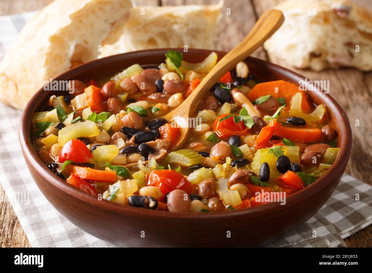 Tasty three bean soup with vegetables in a bowl close-up on the table. horizontal Stock Photo