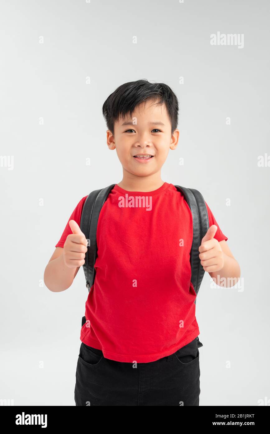 Happy young asian school boy with thumbs up isolated on a white background. Stock Photo