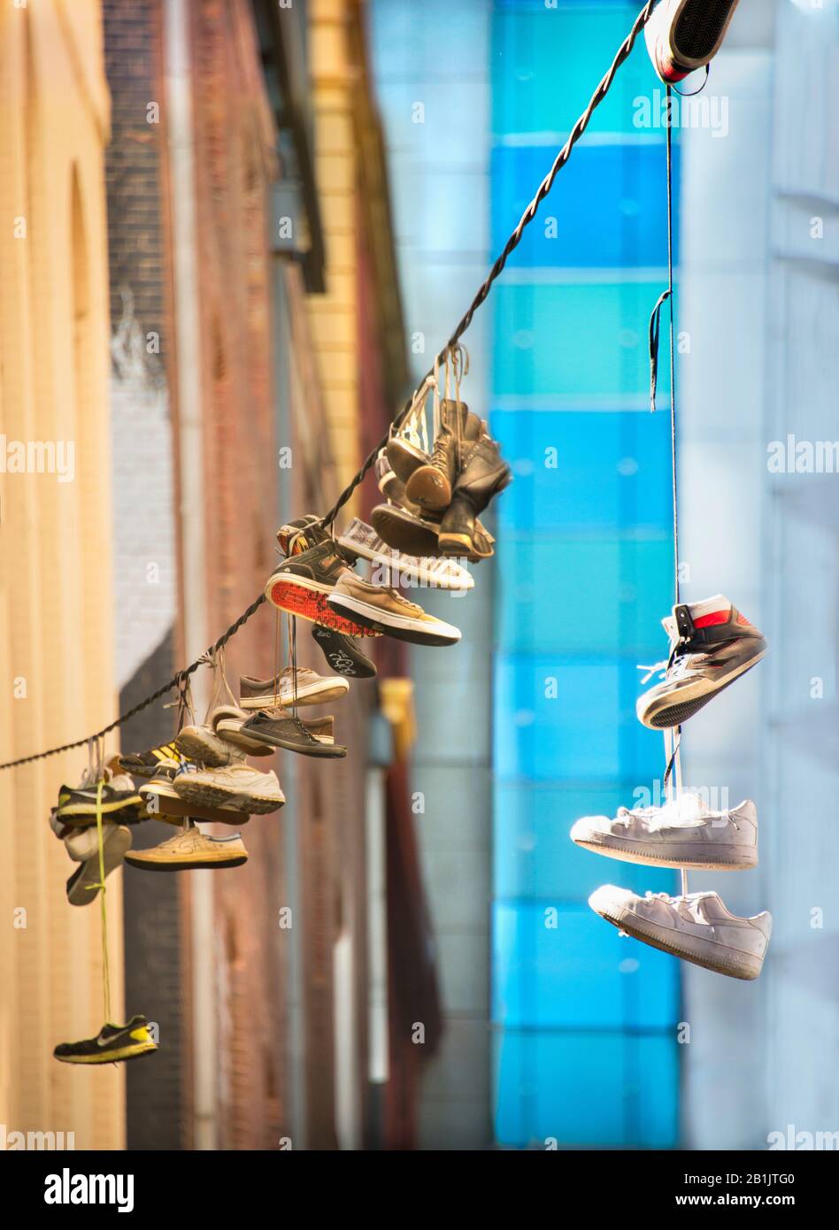 Shoes hanging from power line in inner city  back street Hosier Street, Melbourne Lanes, Melbourne, Victoria, Australia Stock Photo