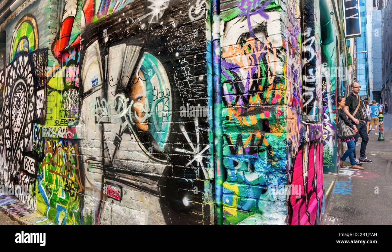 Tourists exploring graffiti filled brick wall down the alley ways Hosier Street, Melbourne Lanes, Melbourne, Victoria, Australia Stock Photo