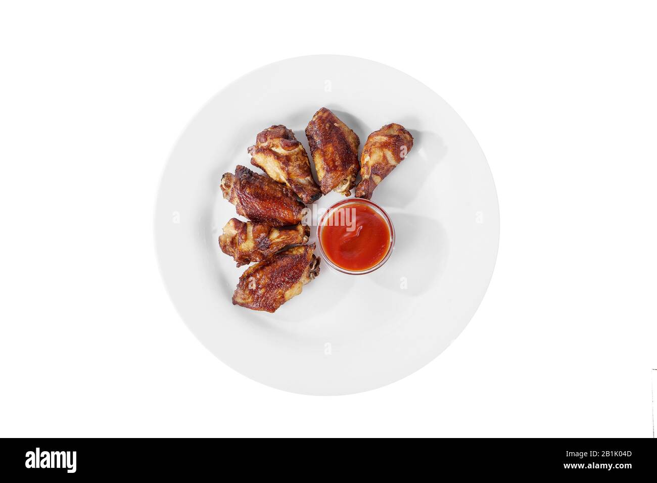 Hot appetizer chicken pieces, legs, wings, fried in oil, tomato sauce, ketchup, B-B-Q, before alcohol, on plate, white isolated background, view from Stock Photo
