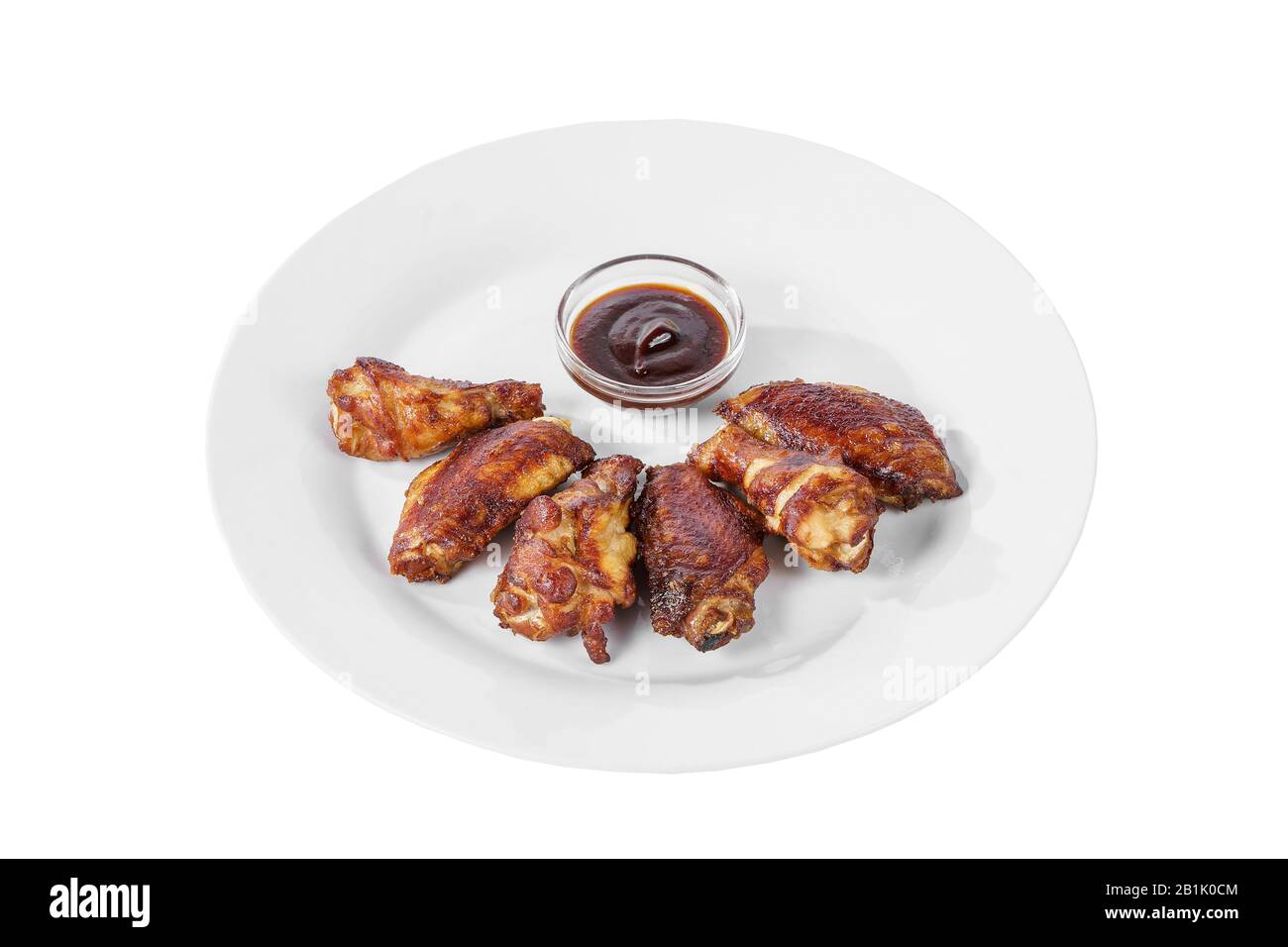Hot appetizer chicken pieces, legs, wings, fried in oil, tomato sauce, ketchup, B-B-Q, before alcohol, on plate, white isolated background, Side view. Stock Photo