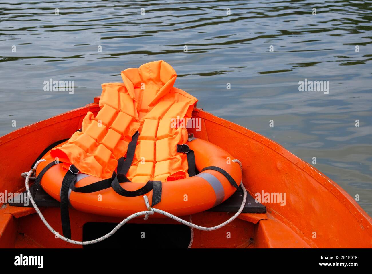 Outfit of lifeguard on water in summer boat, life jacket, lifebuoy in orange color. Concept rescue on water in summer. Stock Photo