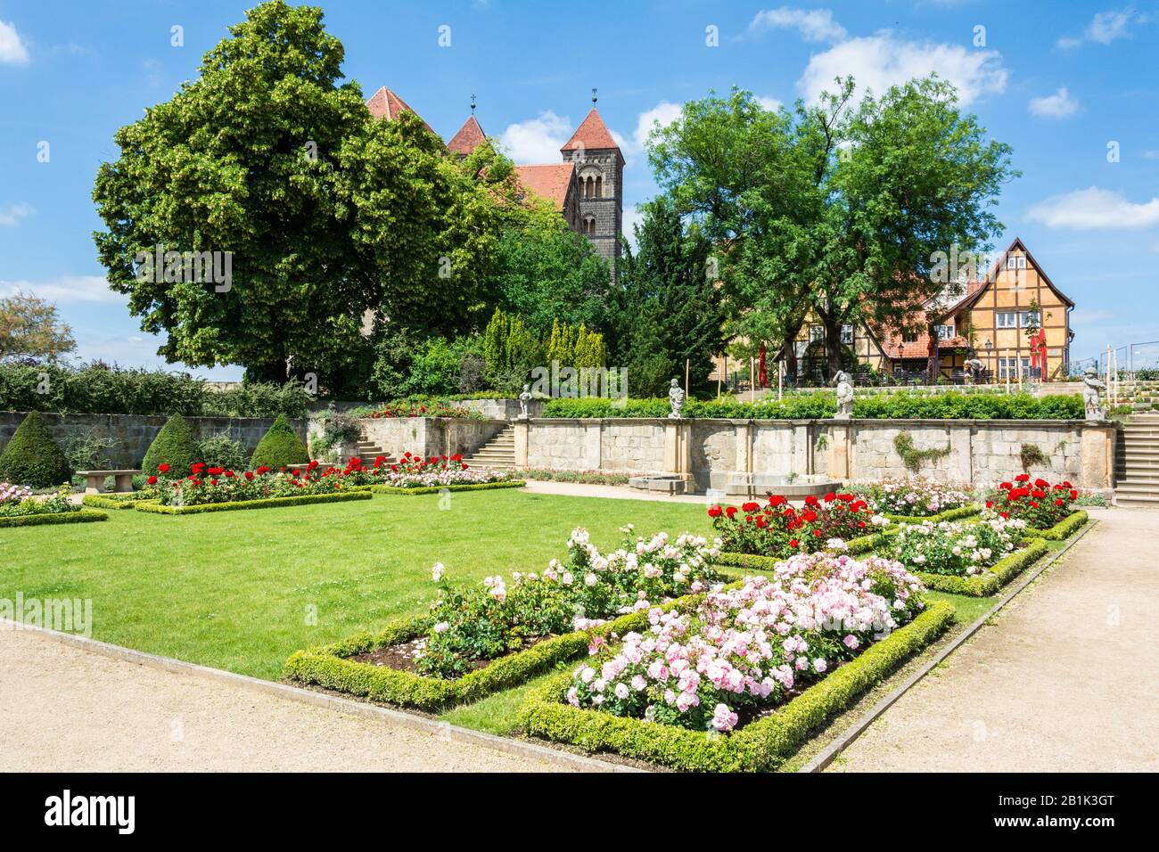 Quedlinburg, Germany – June 20, 2016. Schlossgarten Quedlinburg garden with vegetation and towers of Stiftskirche St. Servatius in the background. Stock Photo