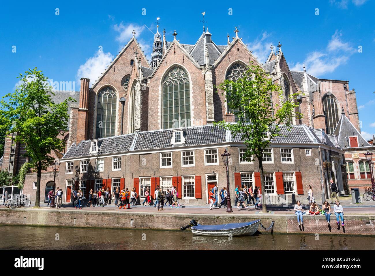 Amsterdam, The Netherlands – June 22, 2016. Exterior view of Oude Kirk church in Amsterdam, with people and bicycles. Oude Kirk is the oldest building Stock Photo