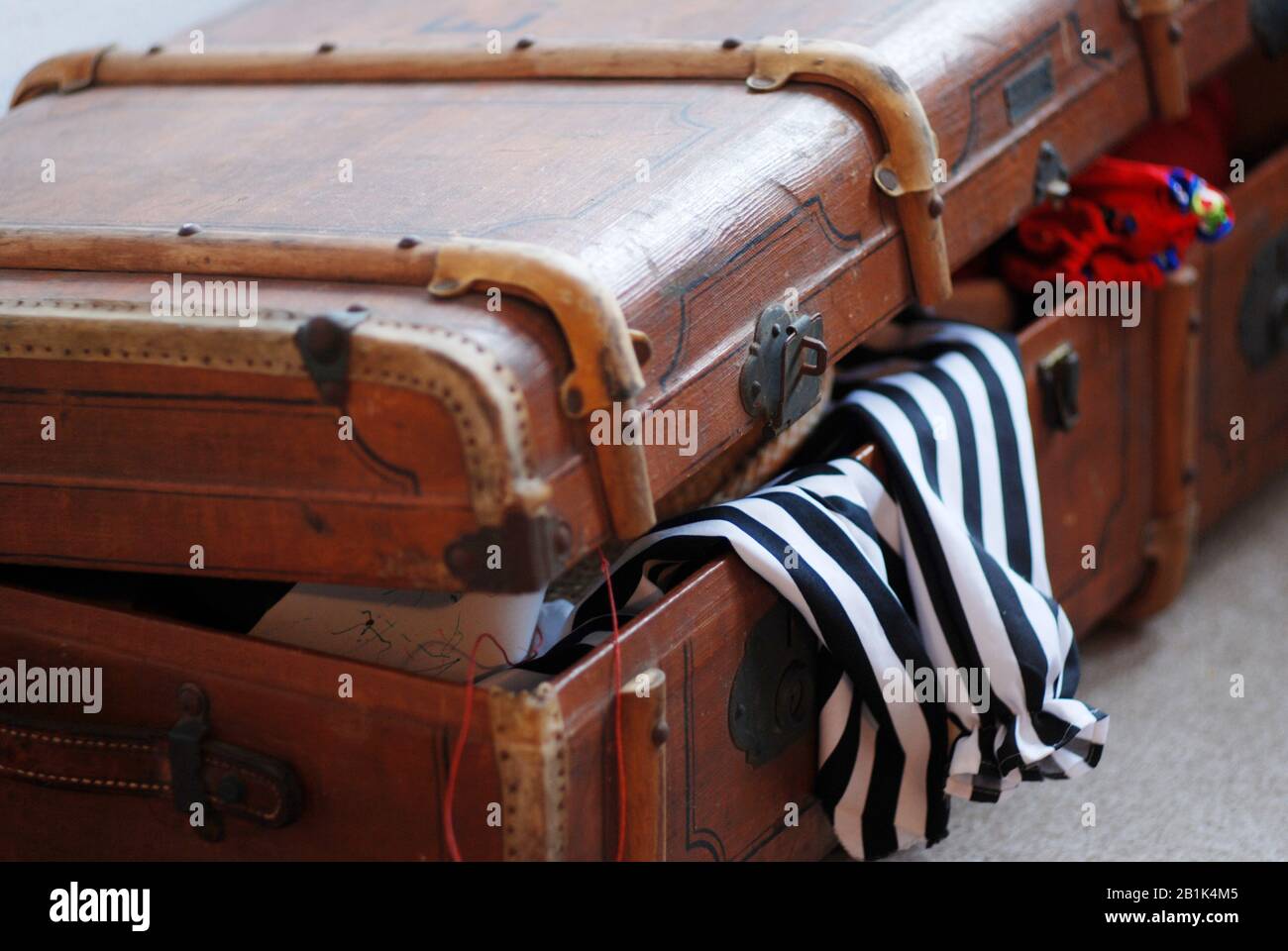 Vintage old nostagic retro travel case with stored textile fashion lurking out Stock Photo