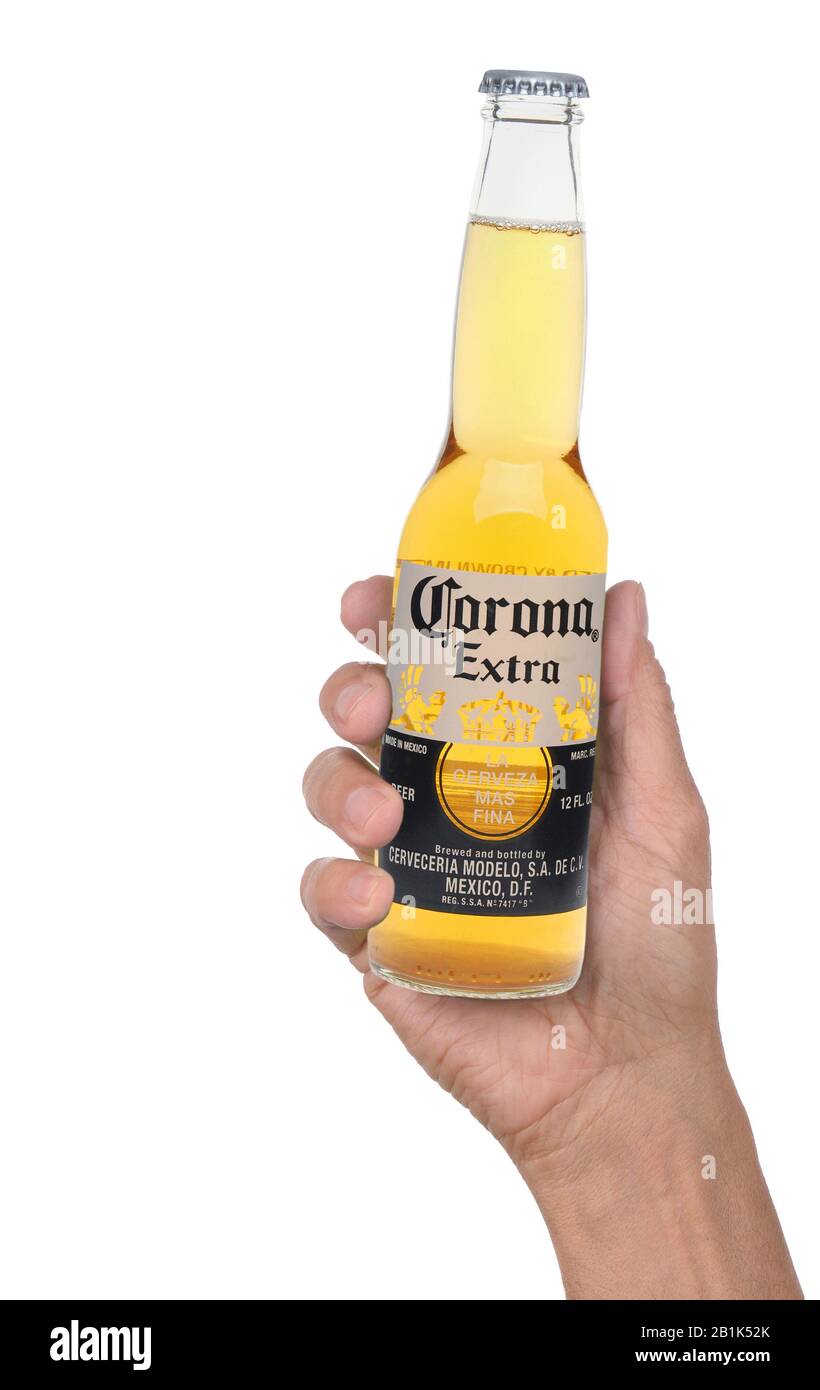 IRVINE, CALIFRONIA - MARCH 31, 2019: Closeup of a man holding a Corona Extra beer bottle in his hand over a white background. Stock Photo