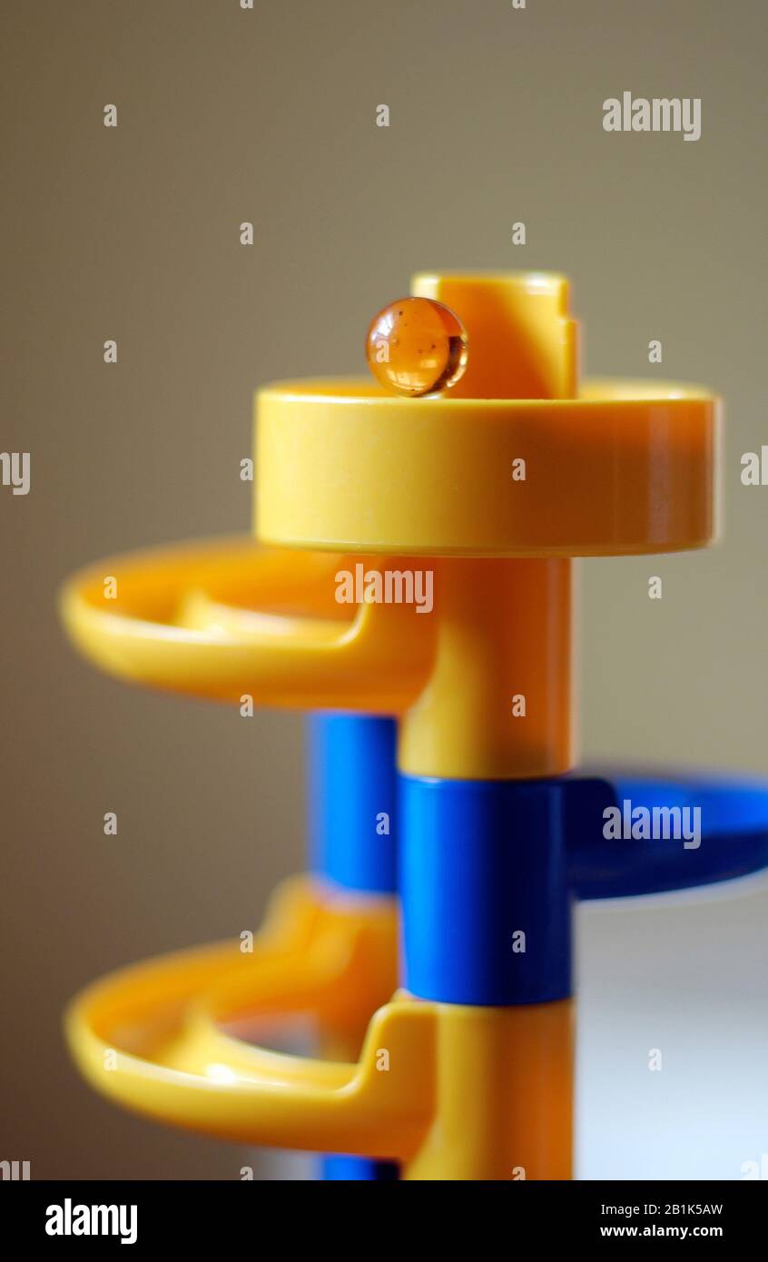Yellow glass marble on a marble run concept game Stock Photo Alamy