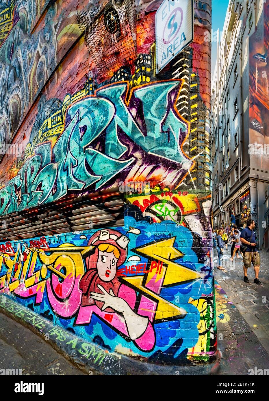 Cartoon style painting on heavily graffit wall down cobbled stone alley way, with people in background, Hosier Street, Melbourne Lanes, Melbourne, Vic Stock Photo