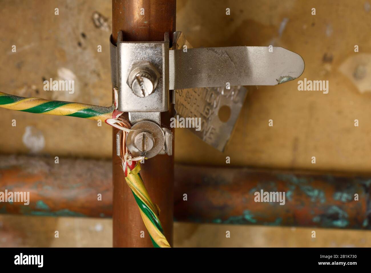 An electrical earth bonding strap on a domestic copper pipe Stock Photo