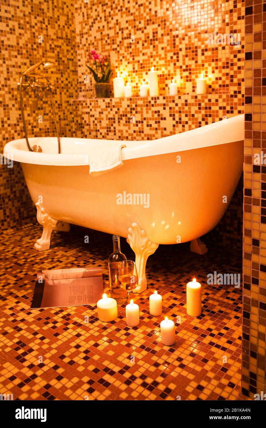 Luxury vintage bathtub in bathroom with orange mosaic ceramic tile