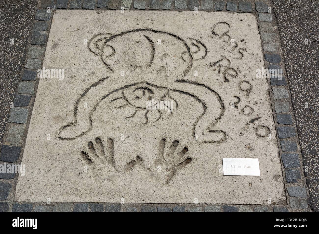 Munich, Germany – July 1, 2016. Mark of English rock and blues singer-songwriter and guitarist Chris Rea with hands and signets in the concrete at the Stock Photo